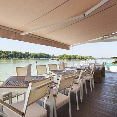 Store sur une terrasse avec quatre tables dans un restaurant
