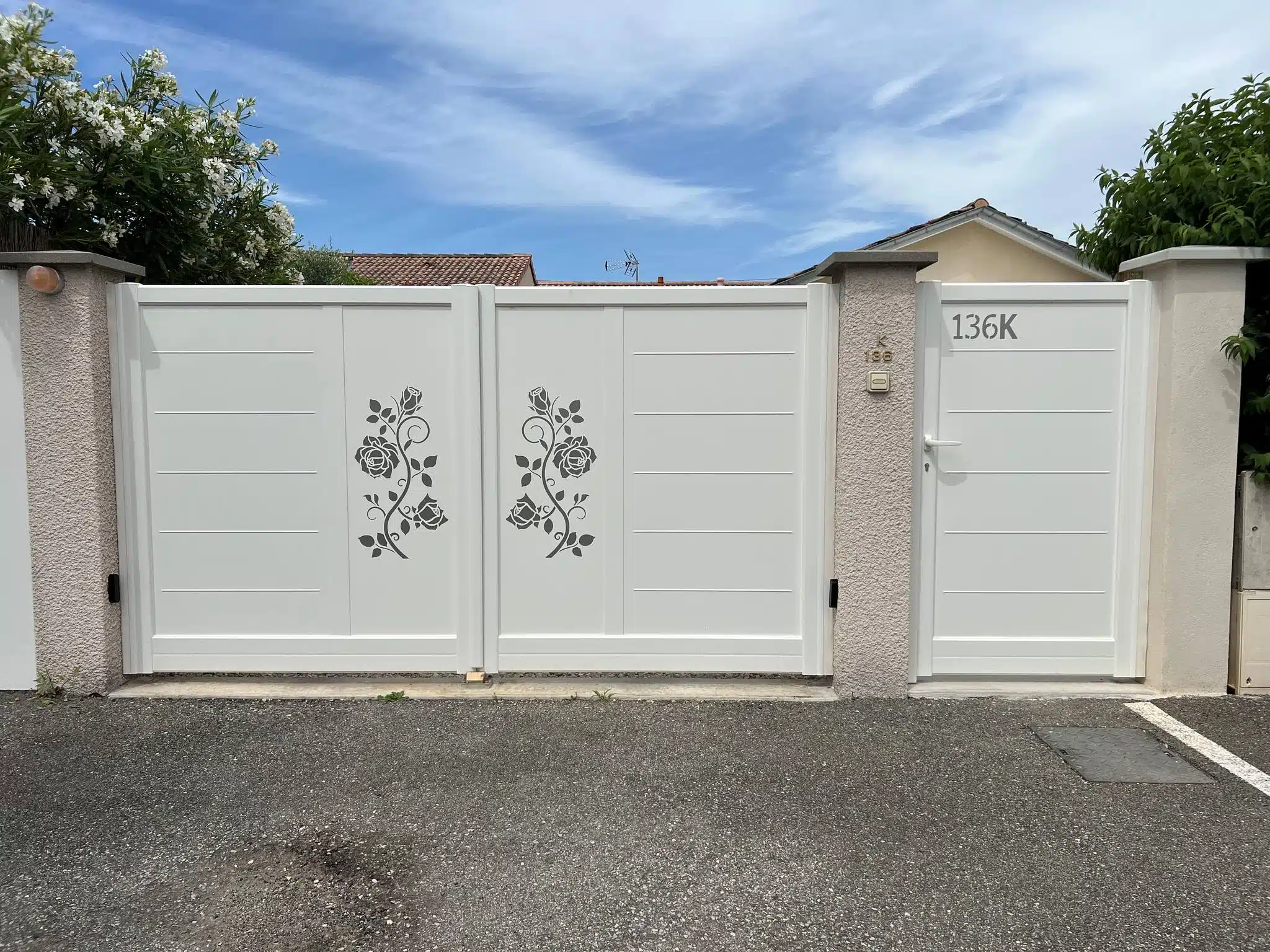 Installation et vente de portail blanc avec portillon assorti à Romans-sur-Isère, avec panneaux décoratifs ajourés motif floral et clôture moderne.